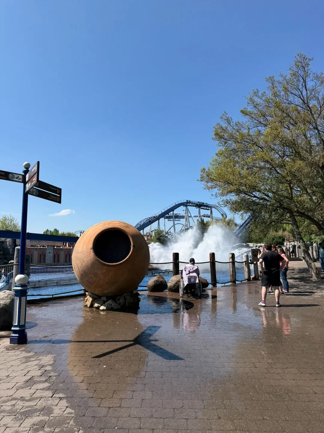 Platz mit Wasserspiel und grossem Tonkrug, hinten eine Achterbahn