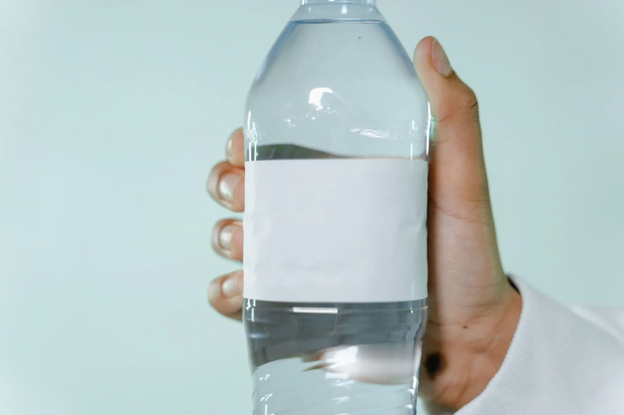 Eine Hand hält eine Flasche Wasser wie eine Wasserprobe