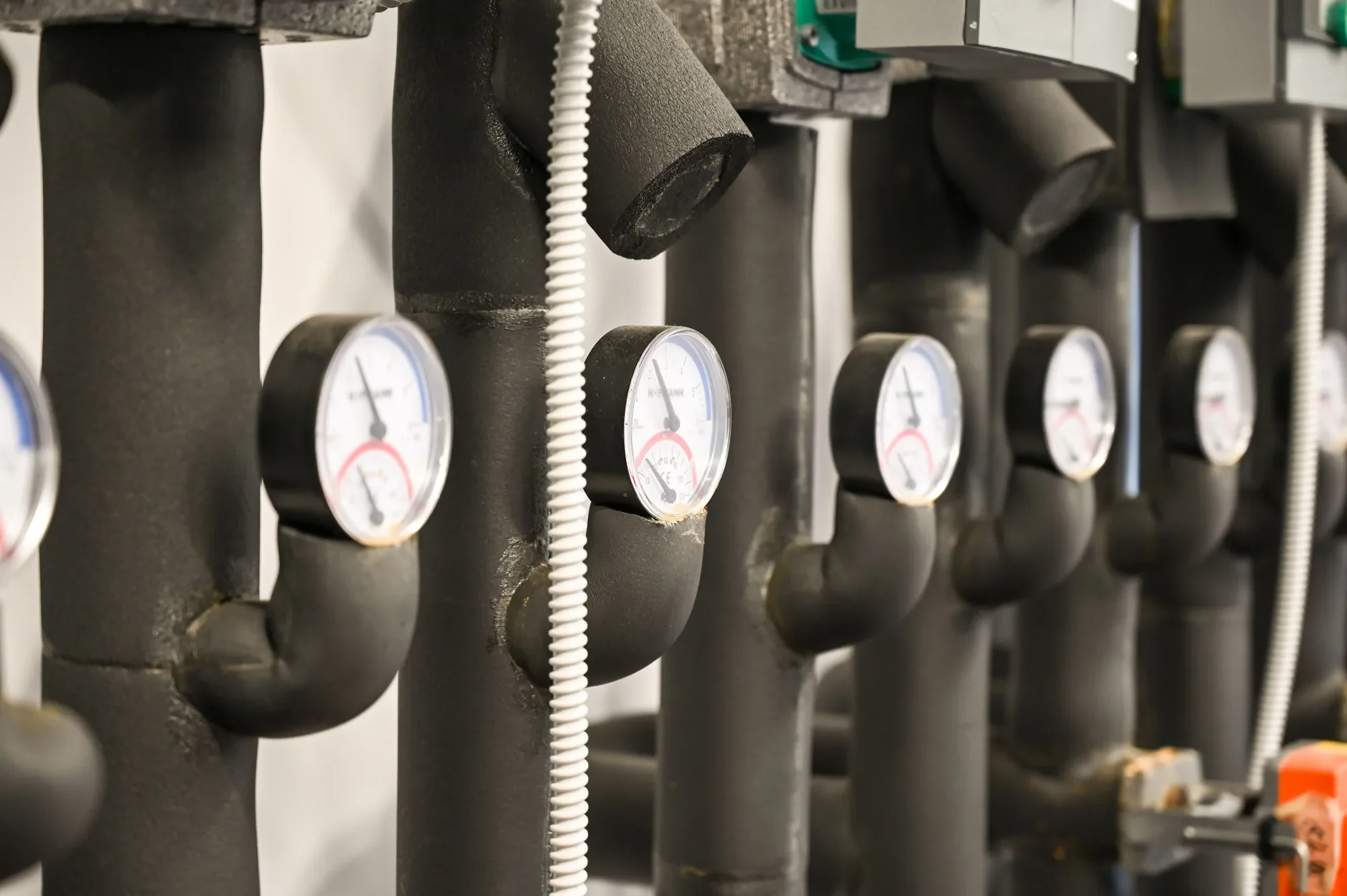 Heizverteilung mit gedämmten Vor- und Rückläufen und je einem Thermometer pro Heizgruppe